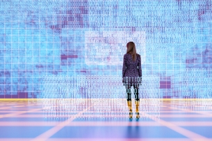 Woman stands before a wall of scientific data